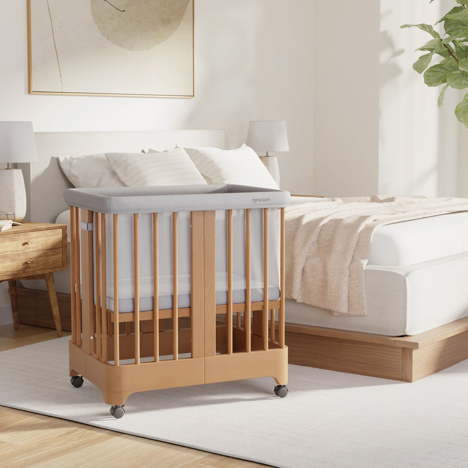 Natural Newton Nest Convertible Crib in bassinet setting next to bed in bedroom