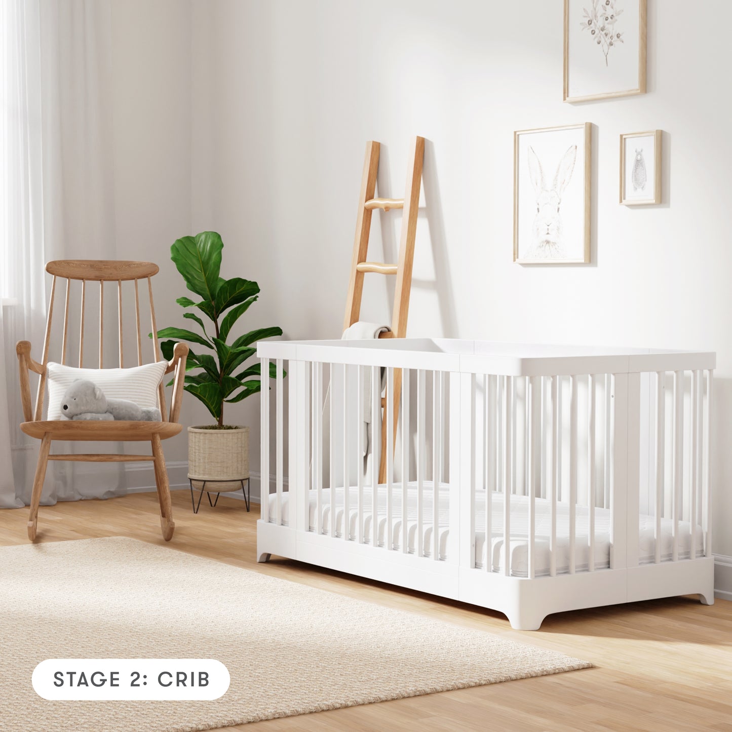 white color Newton Nest Convertible Crib in crib setting, in nursery next to rocking chair, with text "Stage 2: Crib"
