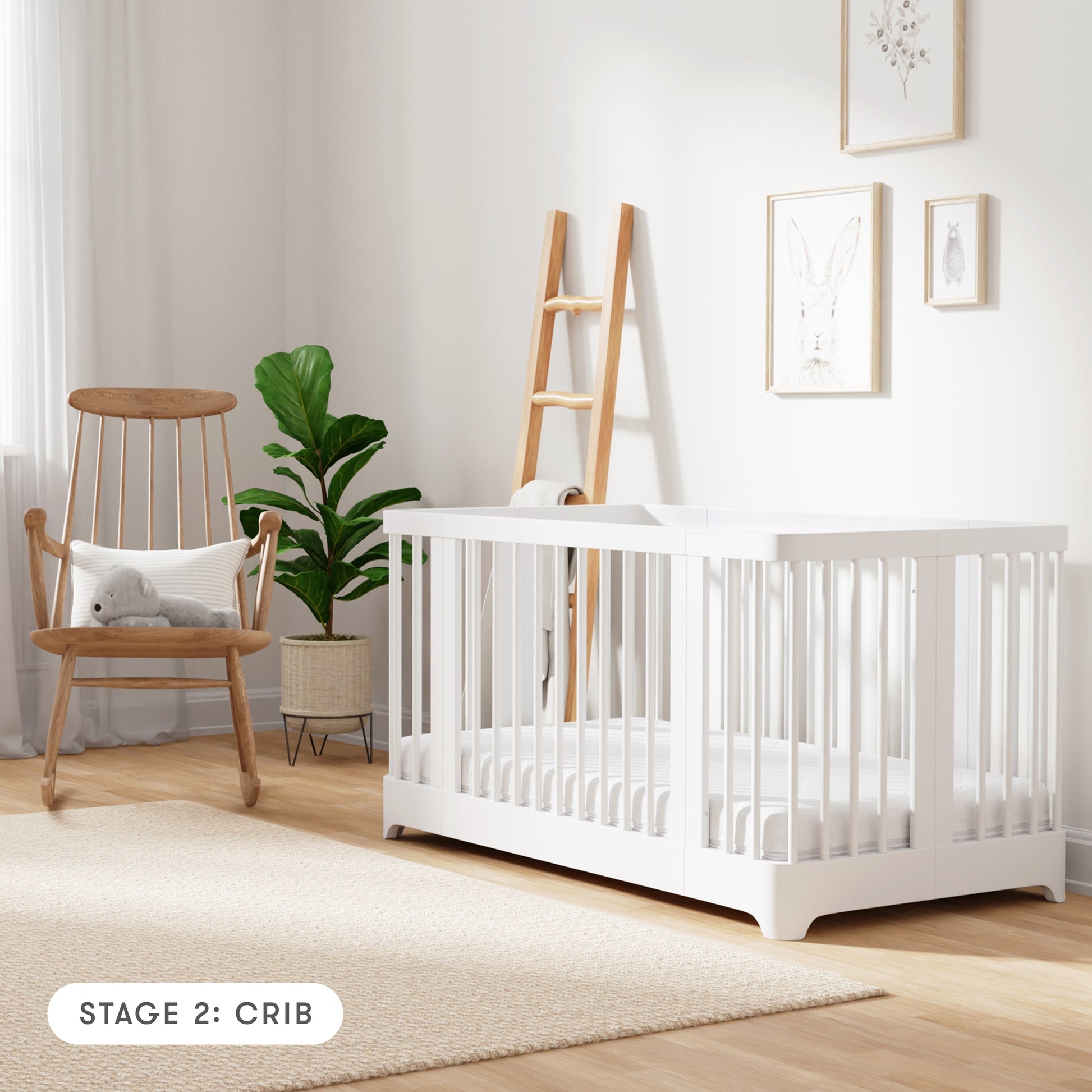 white color Newton Nest Convertible Crib in crib setting, in nursery next to rocking chair, with text "Stage 2: Crib"