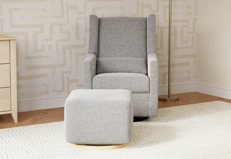 Modern gray nursery rocking chair with a matching ottoman, set on a white rug in a stylish room.