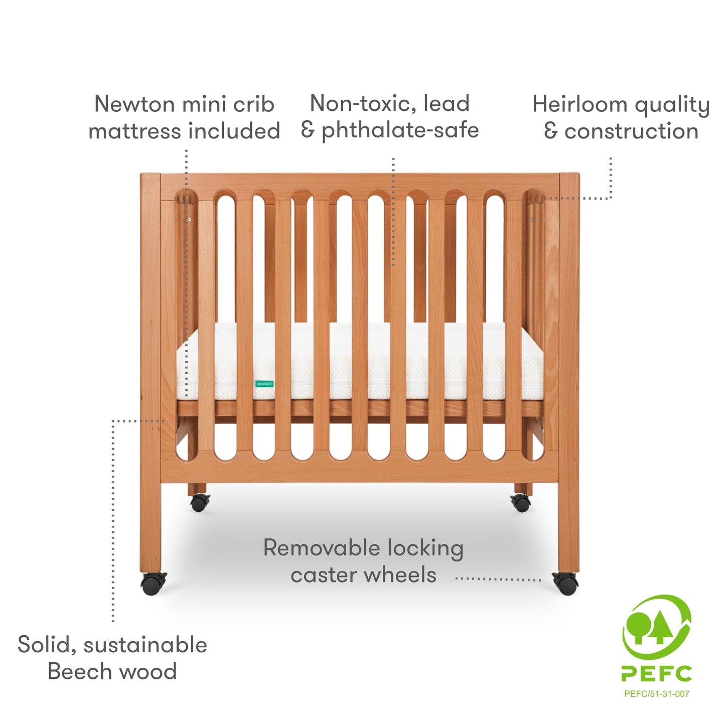 Modern wooden crib on wheels with visible mattress, isolated on a white background. With text "newton mini crib mattress included, non-toxic, lead & phthalate-safe, heirloom quality & construction, removable locking caster wheels, solid, sustainable beech wood." PEFC Certified