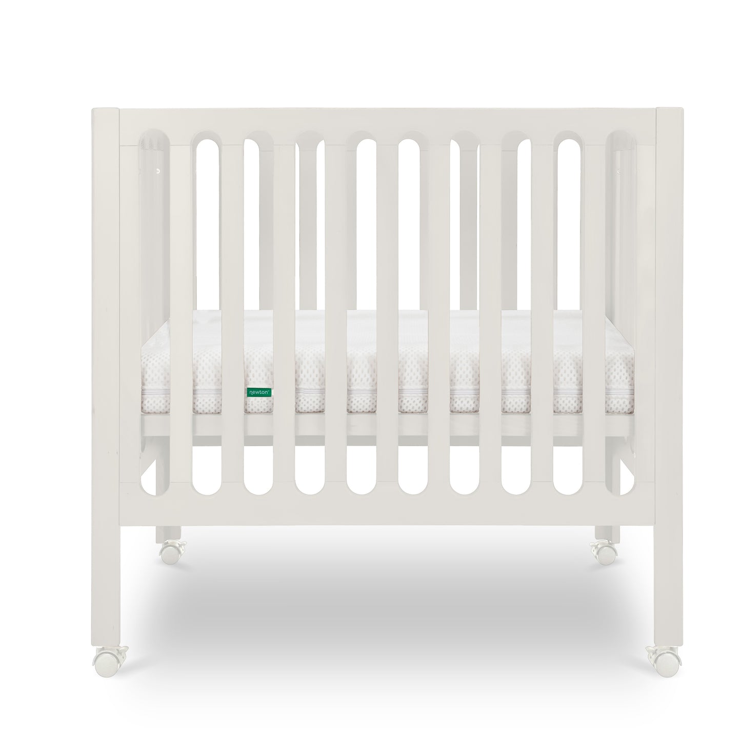 Warm White modern baby crib with a thin mattress on wheels.