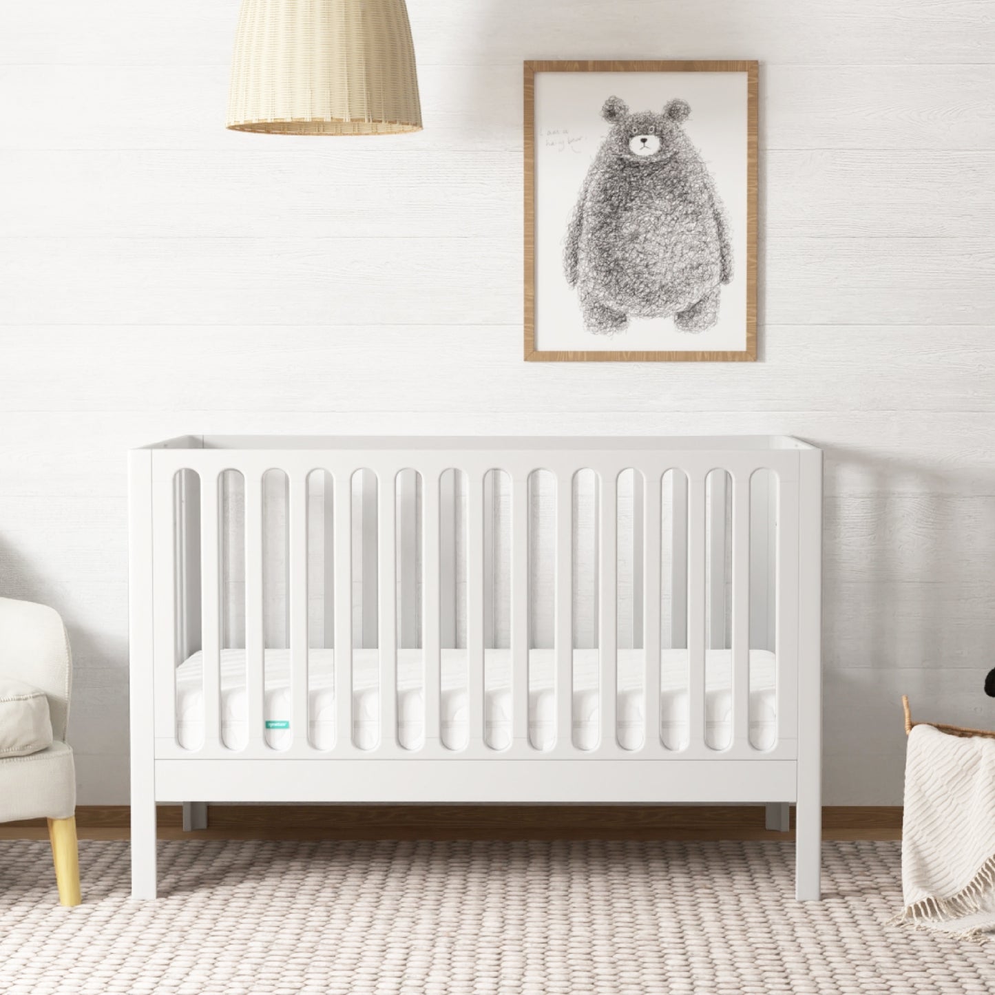 A serene nursery featuring a white wooden crib, white rug, and a bear painting on the wall, decorated with a minimalist art and a gentle color palette. 999-8420-WHT