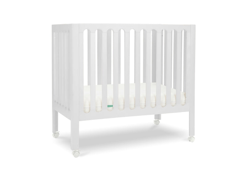 White modern baby crib with a thin mattress on wheels. 999-8430-WHT