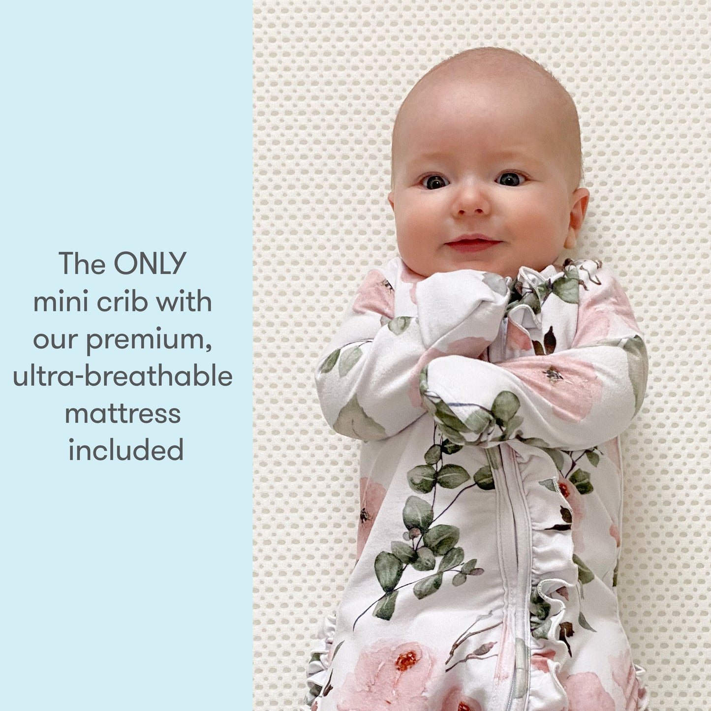 Happy baby lying on an ultra-breathable mattress in a crib with text: "The ONLY mini crib with our premium, ultra-breathable mattress included."