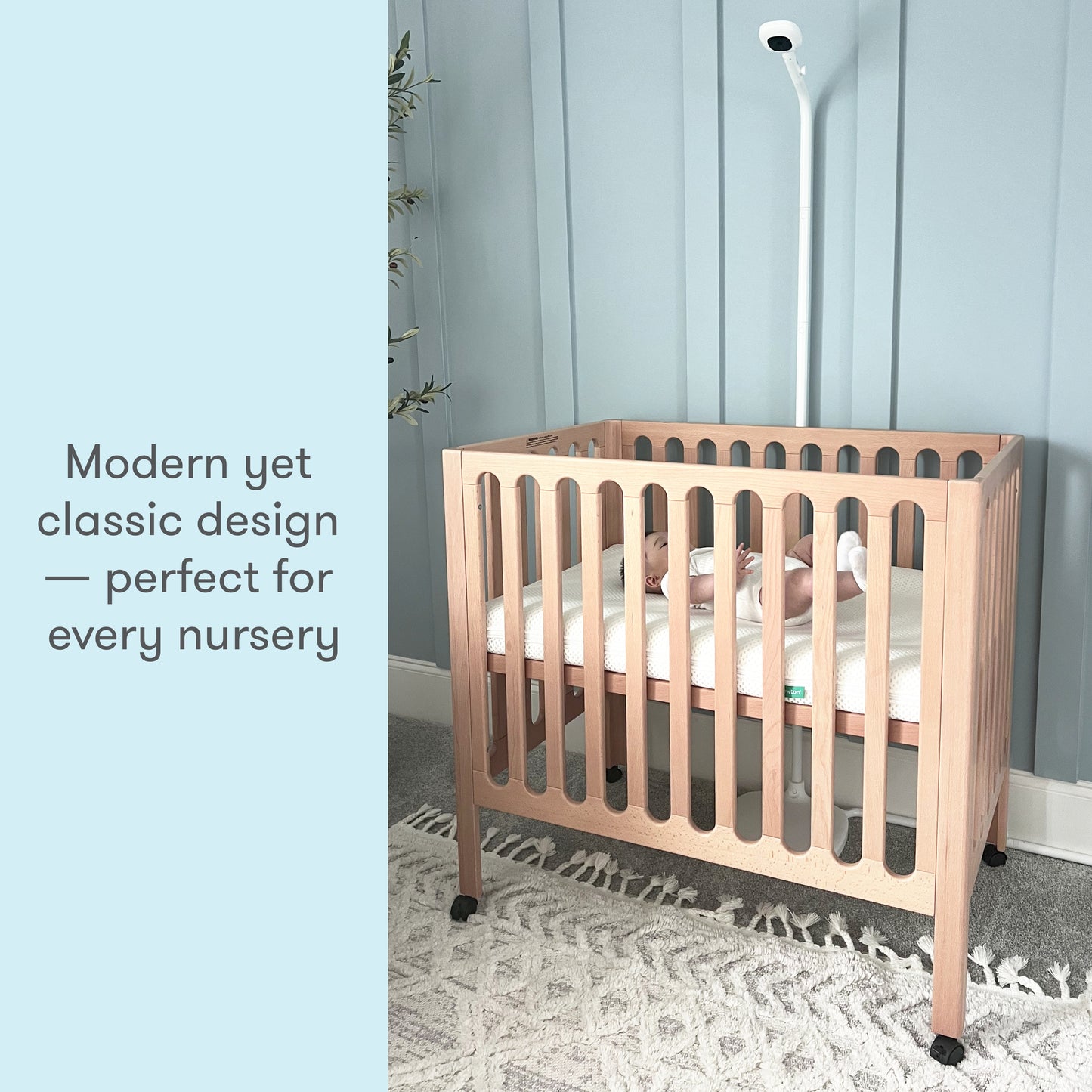 A wooden crib with a sleeping baby in a neutral-toned nursery, accompanied by the text "Modern yet classic design — perfect for every nursery."
