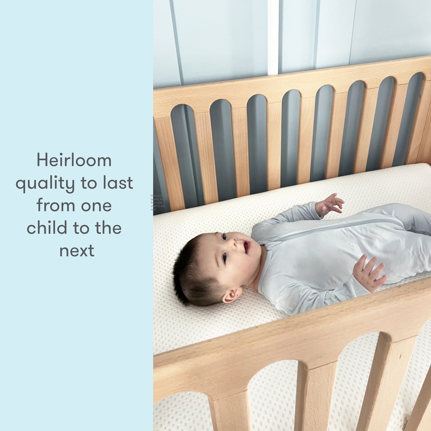 Baby in a gray sleeper lying on a crib mattress with text reading "Heirloom quality to last from one child to the next."