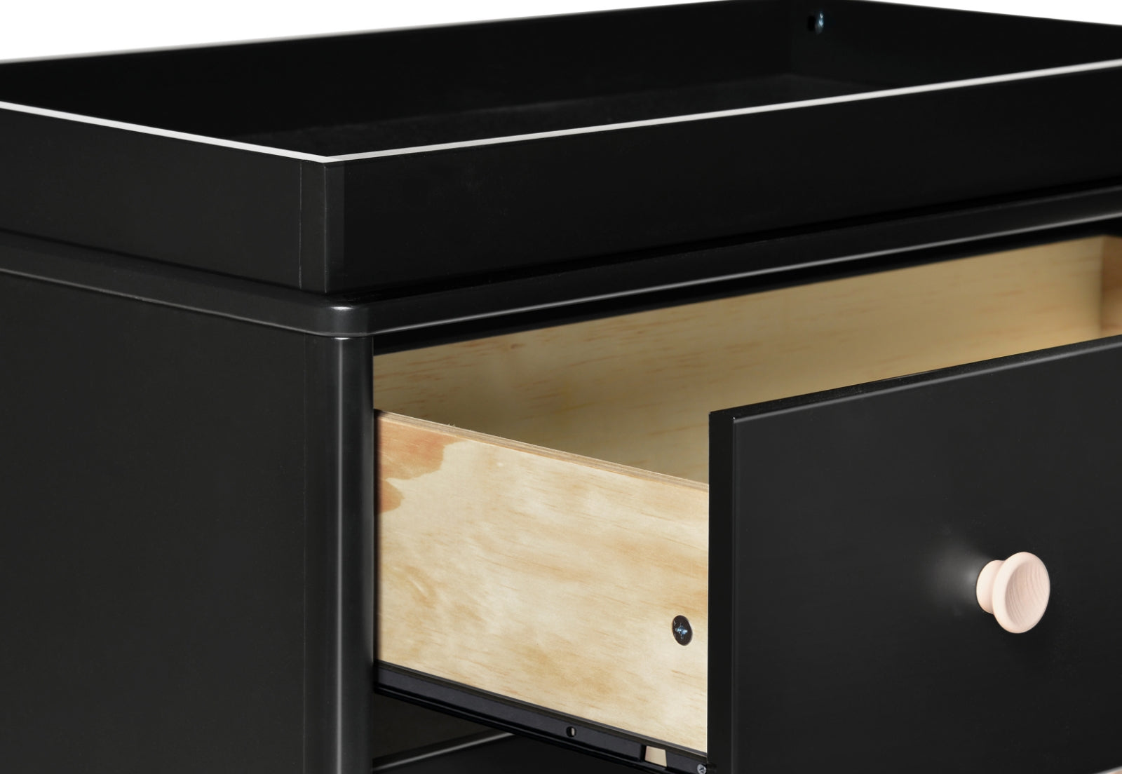 Close-up of a modern black changing table with an open drawer revealing natural wood interior.