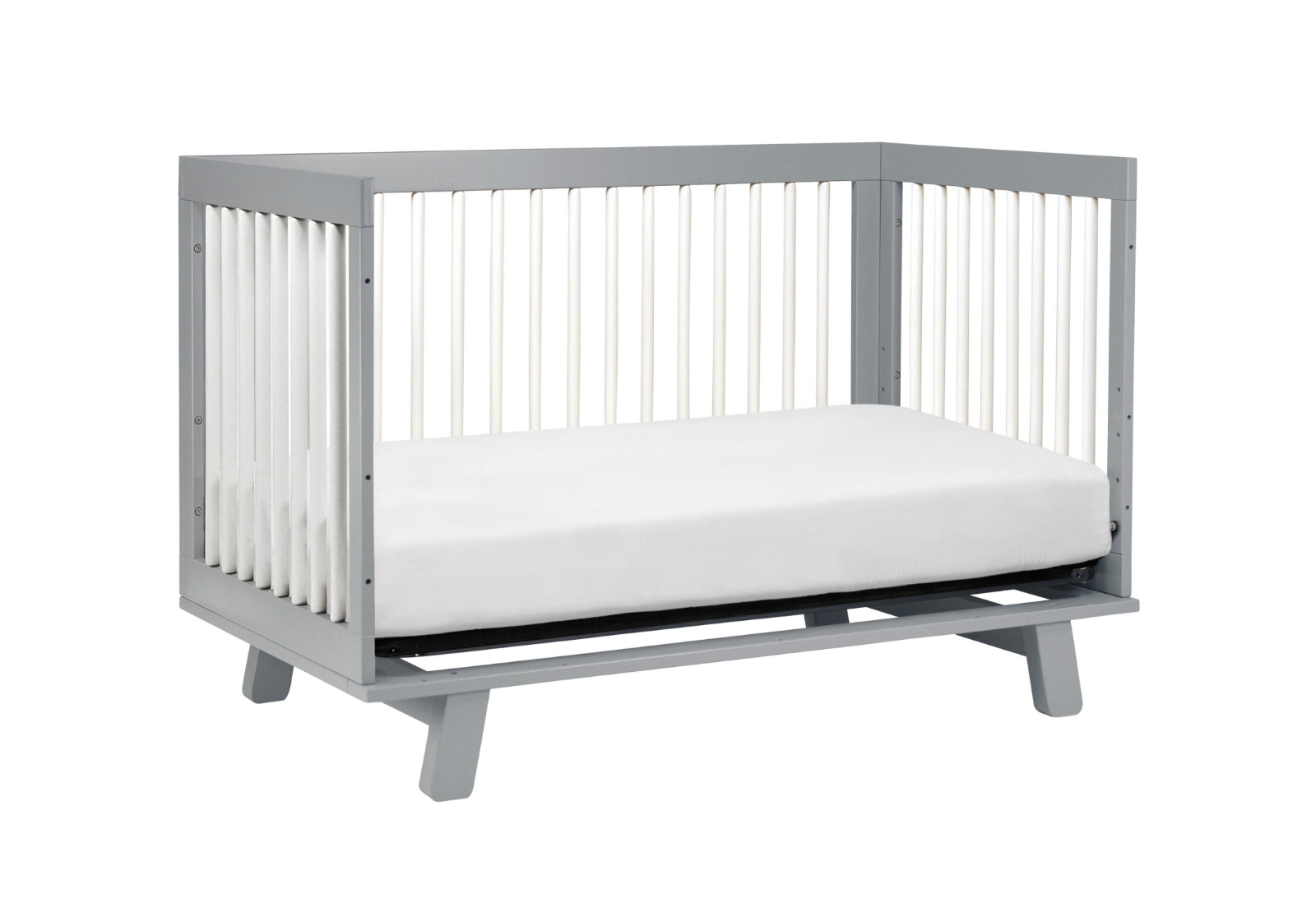 Gray modern baby crib with a white mattress, isolated on a white background.