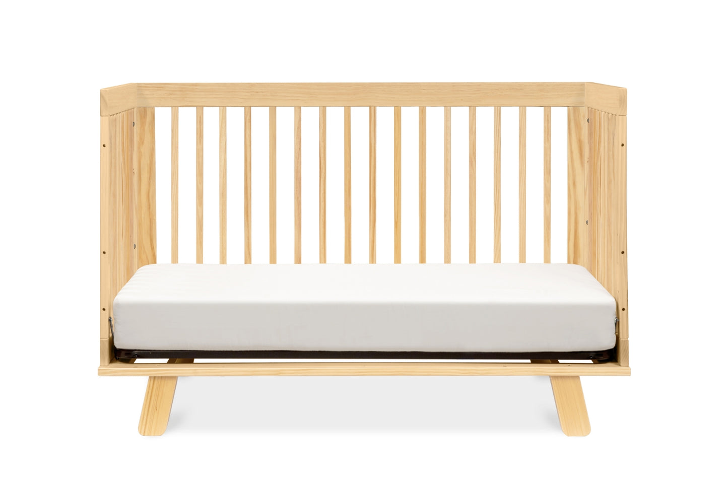 Contemporary wooden crib with a white mattress against a plain background.