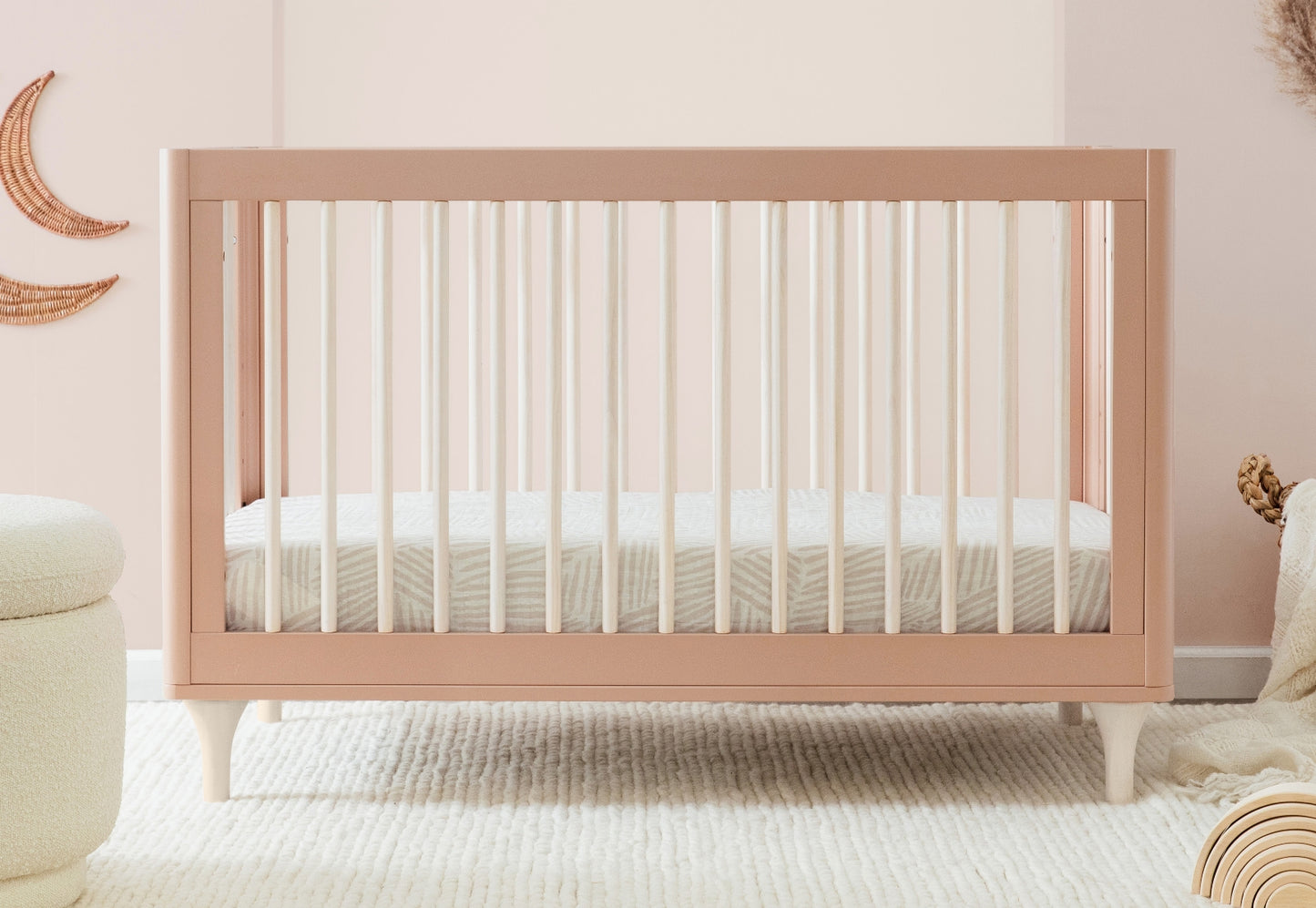 A modern pink baby crib in a cozy nursery setting. 999-8502-CWN