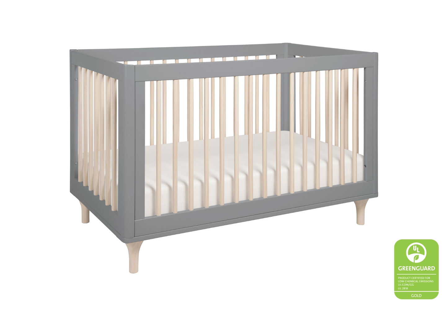 Gray modern baby crib with wooden legs, featuring a GREENGUARD Gold certified logo.