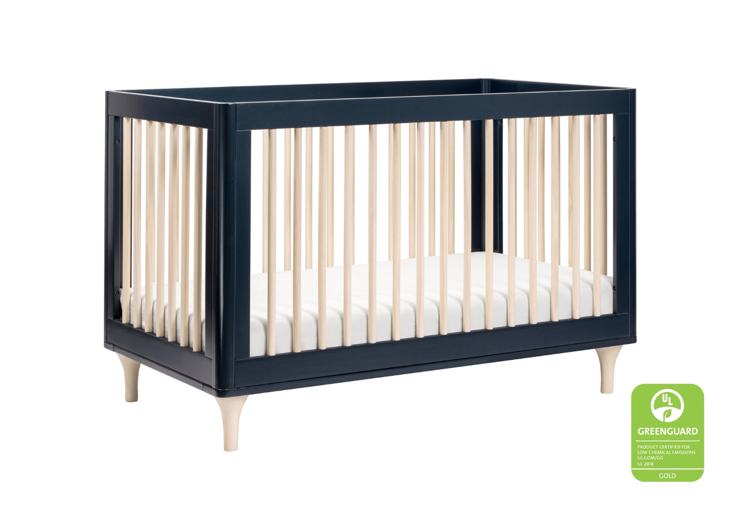 Elegant dark blue crib with contrasting natural wood spindles and legs, featuring a GREENGUARD Gold certification badge for low chemical emissions.