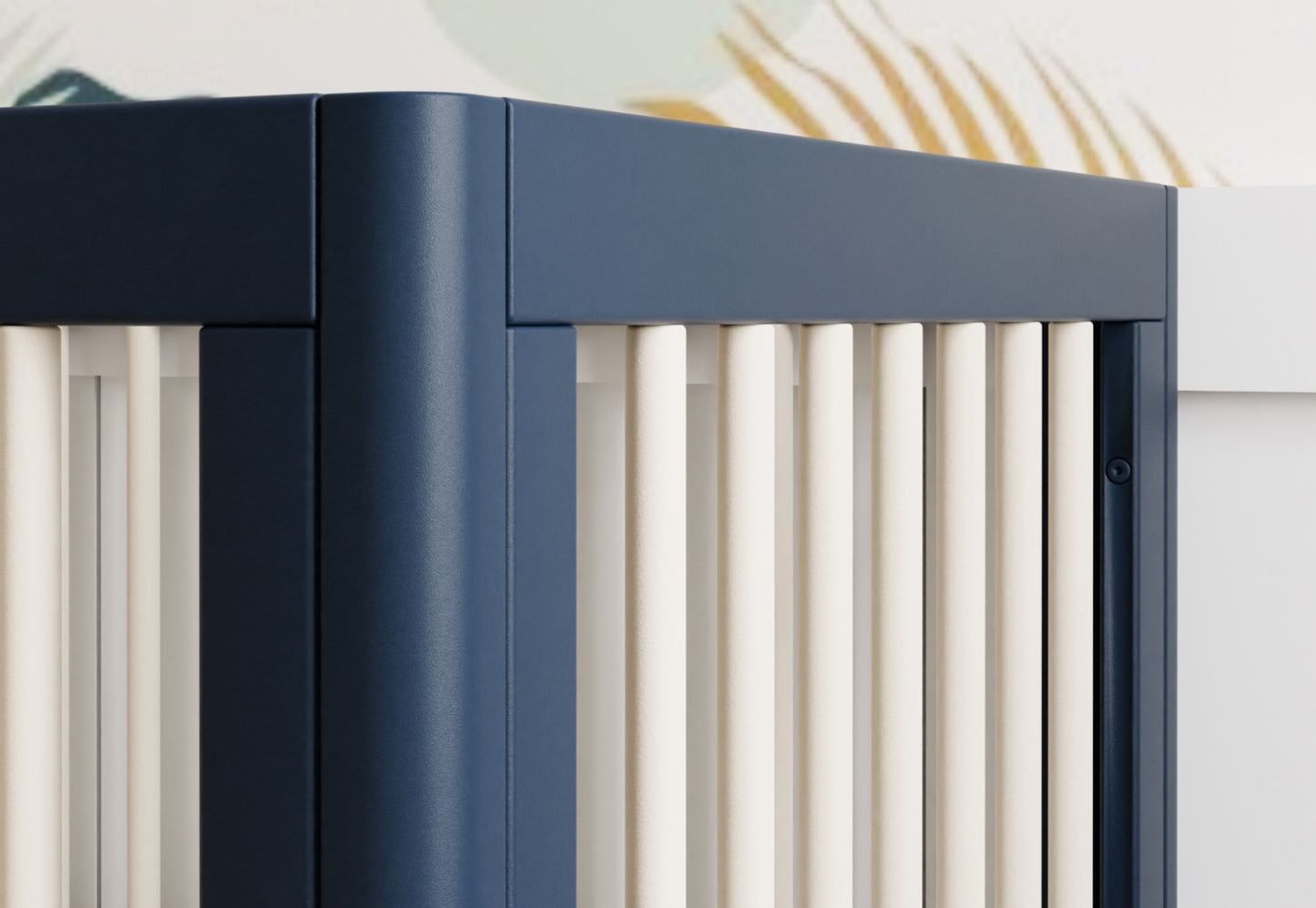 Close-up view of a modern dark blue crib with white vertical slats.