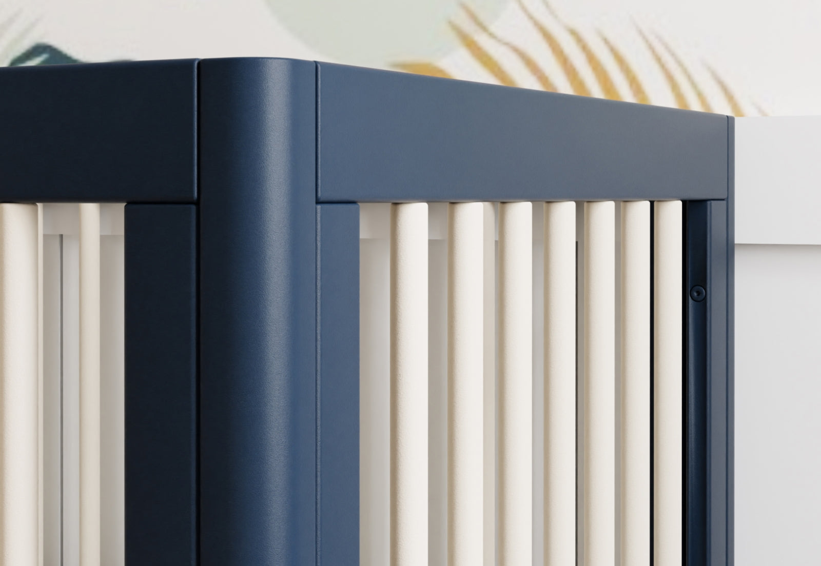 Close-up view of a modern dark blue crib with white vertical slats.
