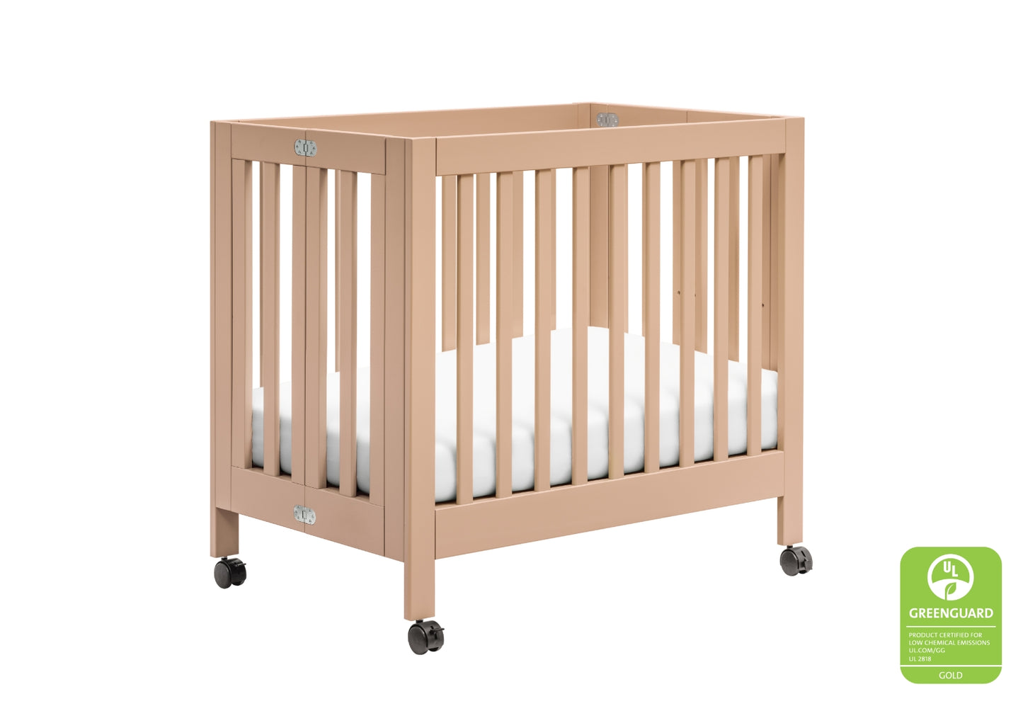 A sturdy beige baby crib on wheels, featuring a GREENGUARD Gold certification emblem for low chemical emissions.