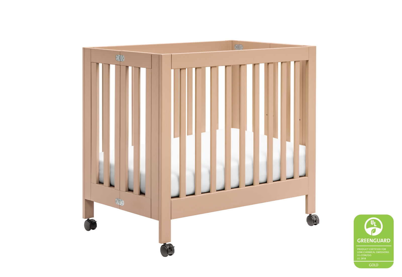 A sturdy beige baby crib on wheels, featuring a GREENGUARD Gold certification emblem for low chemical emissions.