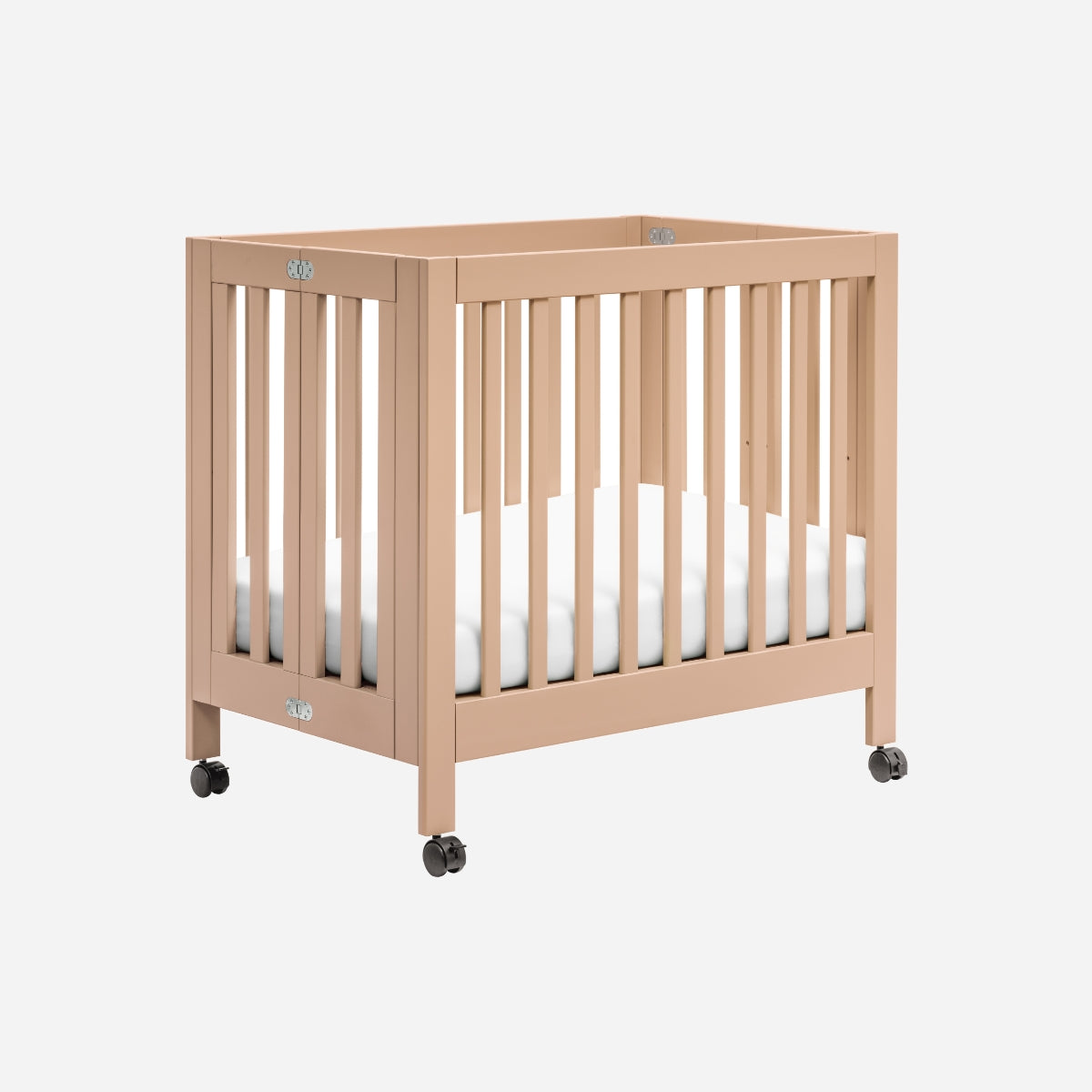 ALT Text: "Minimalist beige baby crib on wheels featuring white bedding and visible brand logos on the frame."