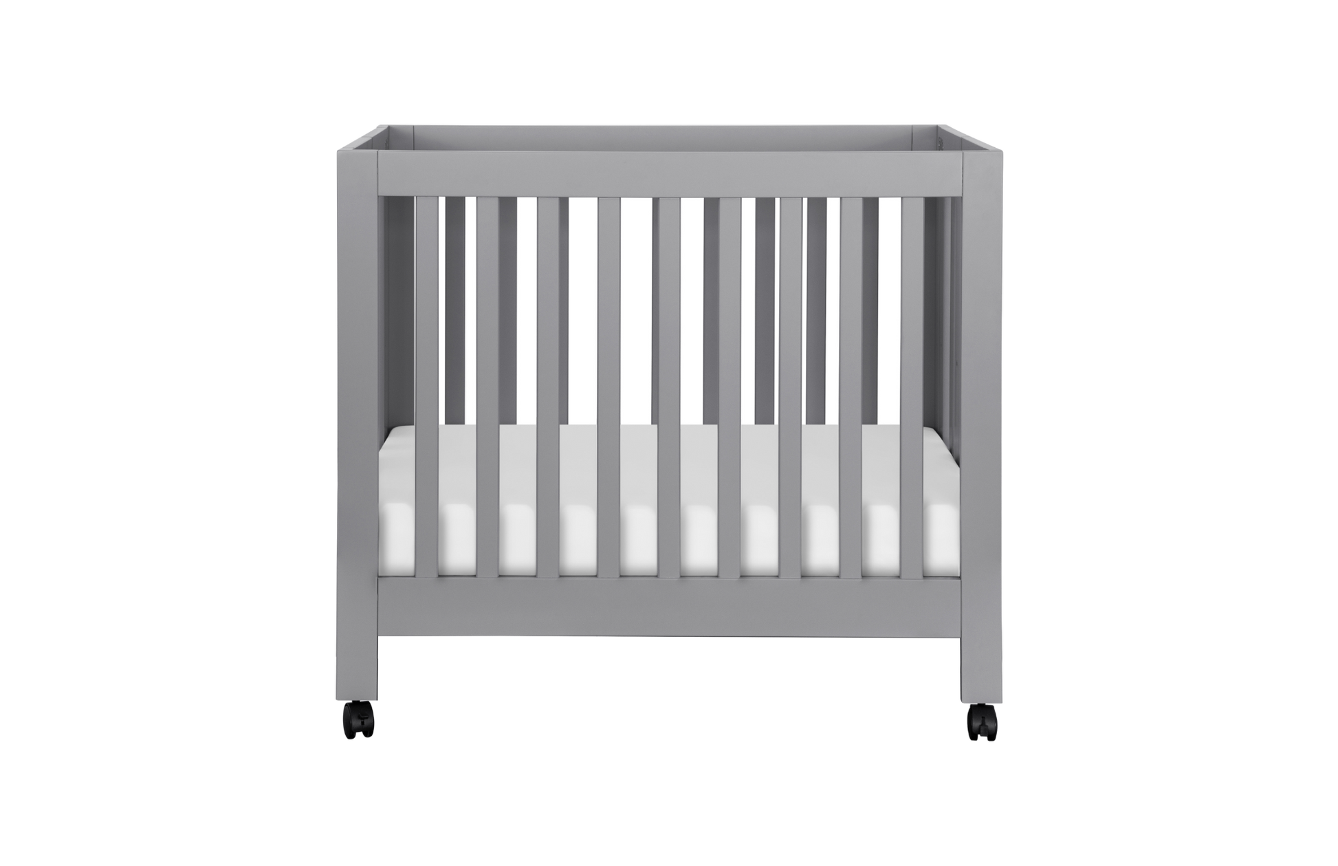 The Babyletto Origami Mini Crib is a modern gray crib with vertical slats, white mattress, and small black wheels. Its portable design is ideal for small spaces. Shown on a plain background.