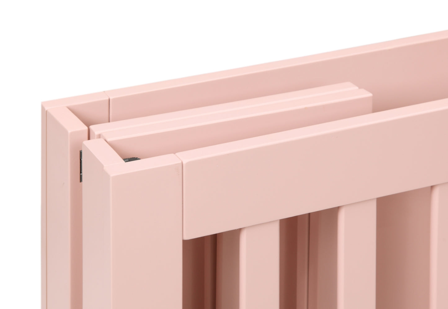 Close-up view of the corner of a light pink baby crib showing the joint and craftsmanship details.