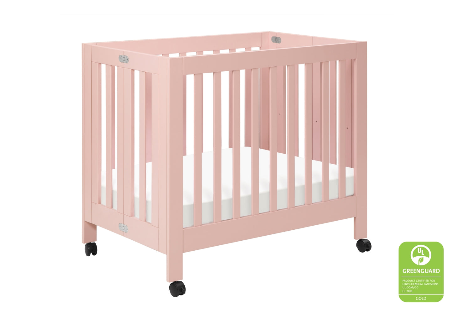Pink baby crib on wheels with a Greenguard Gold certification badge.