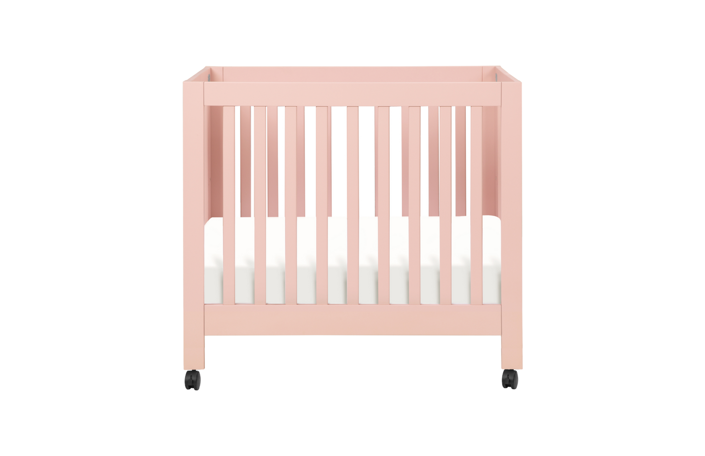 The Babyletto Origami Mini Crib is a stylish pink portable crib with slatted sides, white mattress, and four black wheels—ideal for small spaces, shown on a plain white background.