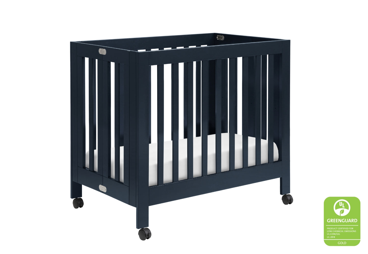 Navy blue baby crib on wheels with a white mattress, featuring a GREENGUARD Gold certified sticker.