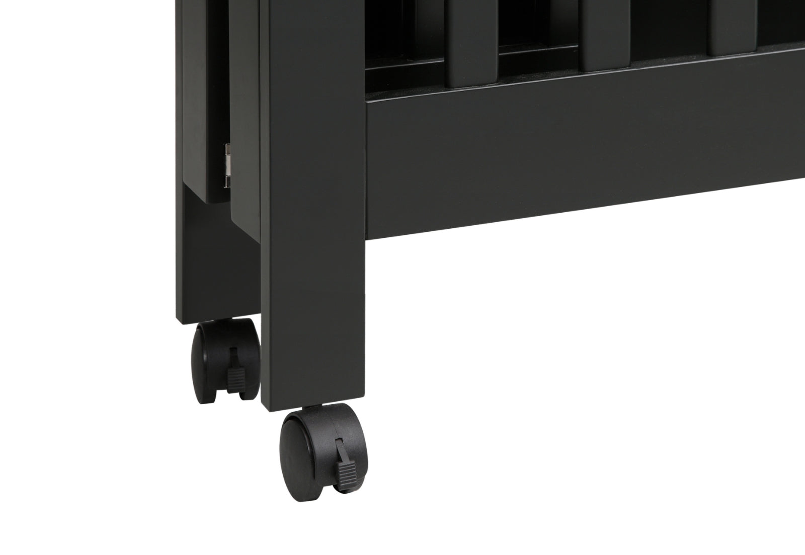 Close-up of a black crib's leg with lockable caster wheels for easy mobility.