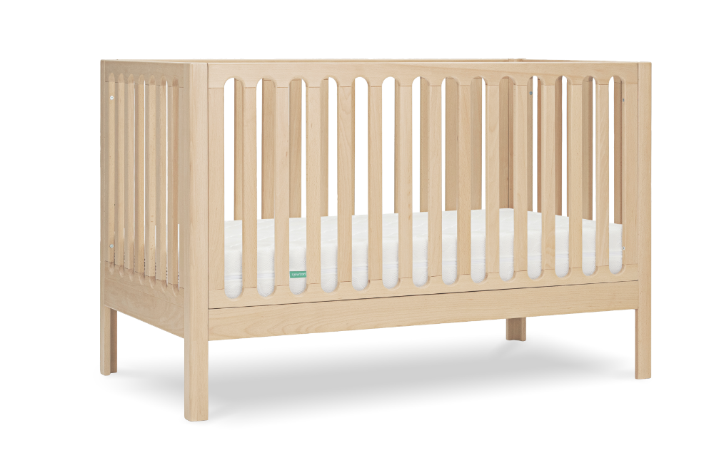 Simple wooden crib with slatted sides on a transparent background, featuring a small green logo at one end.