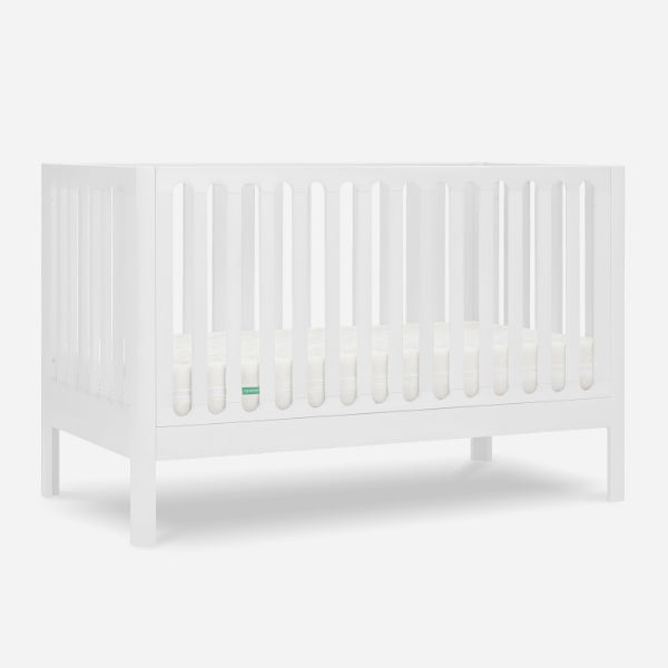 White baby crib with slatted sides and a visible mattress, isolated on a gray background. skip