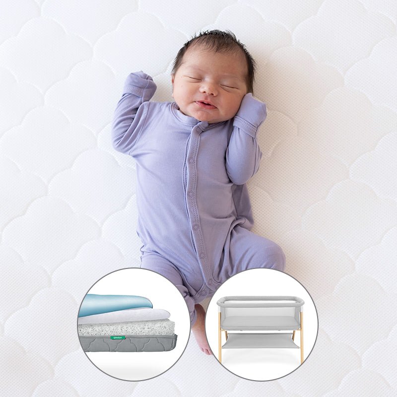 sleeping baby on newton mattress with small circular cutouts of Grey Newton waterproof mattress and essential bassinet on a white background