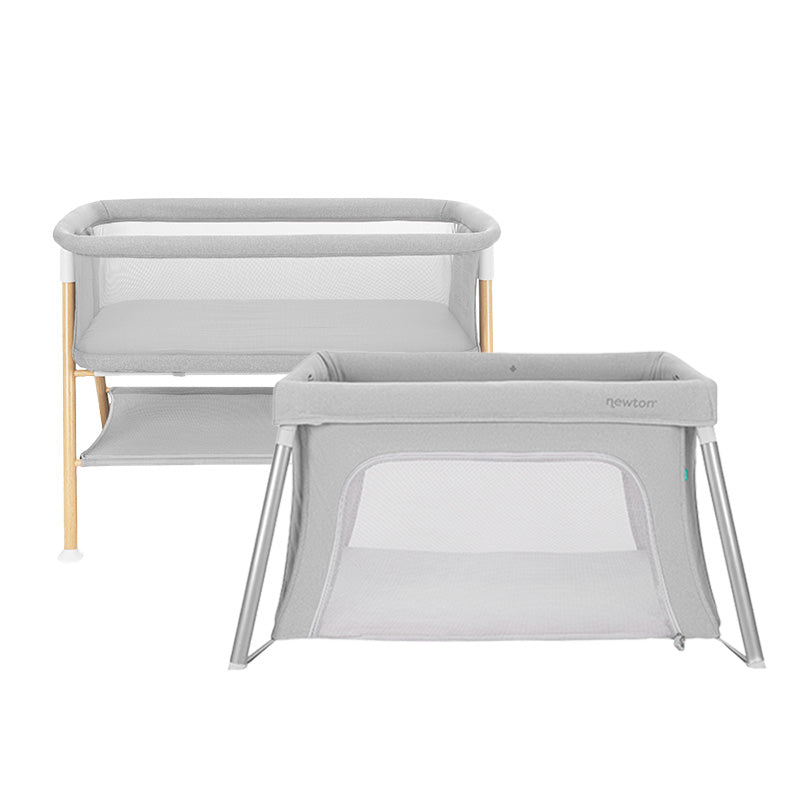 Bundle 4 BFCM by Newton Baby includes two modern, light gray bassinets with mesh sides and minimalist frames—one features wooden legs with a storage shelf, the other is fully metal.