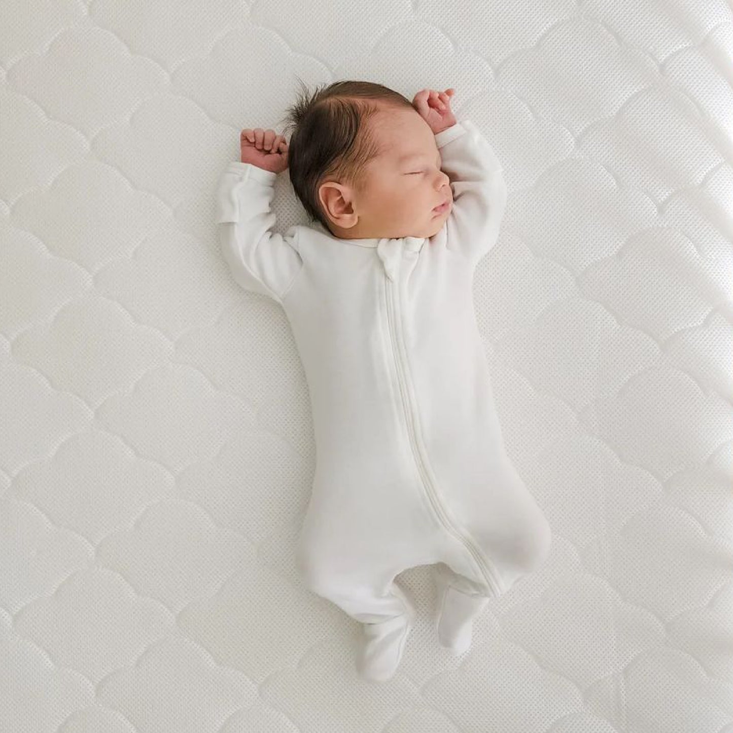 baby lying asleep on newton mattress