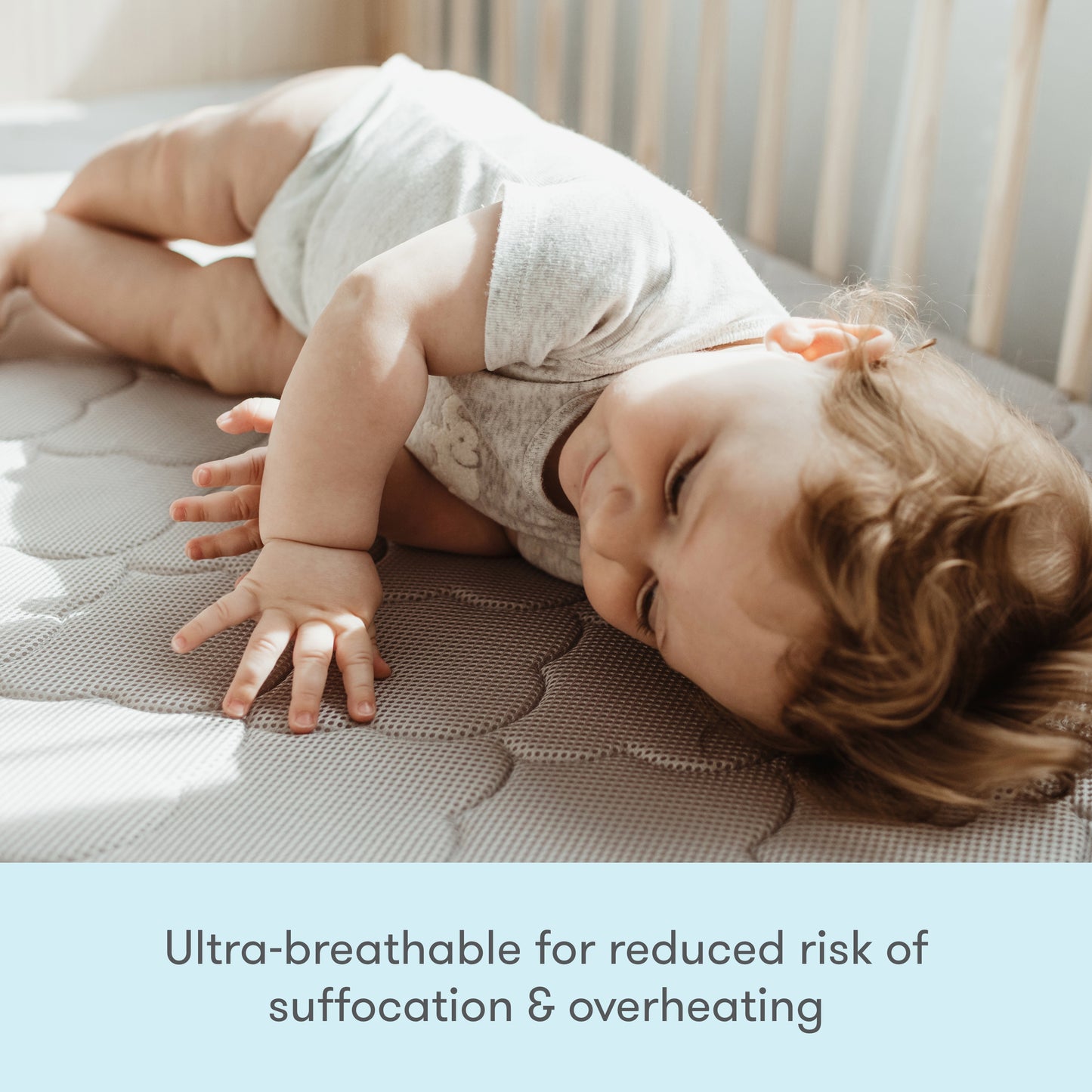 A baby lying on their stomach on a breathable crib mattress, with text stating "Ultra breathable for reduced risk of suffocation & overheating."