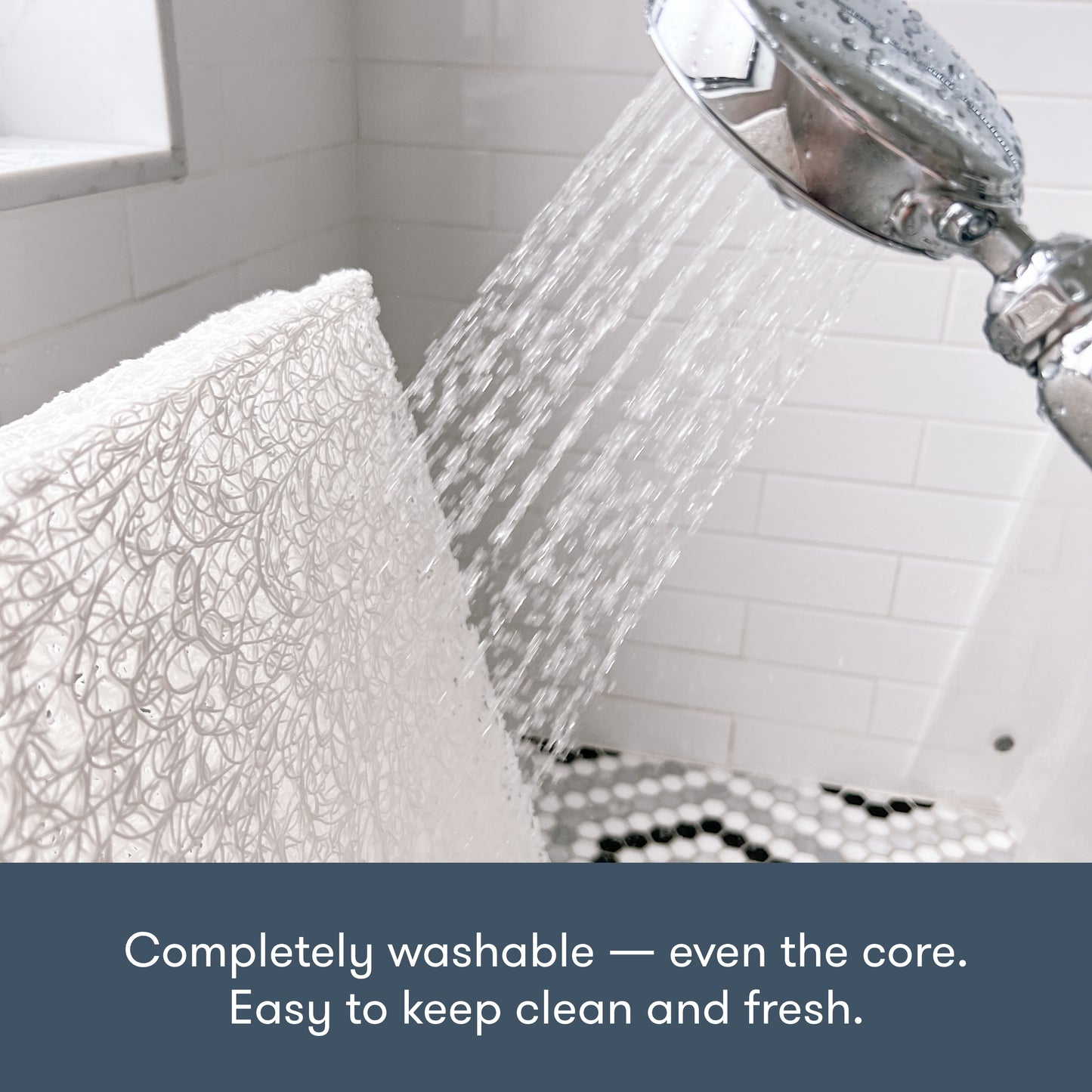 showerhead spraying water and washing down a newton pet bed core in the shower, with text "completely washable -- even the core. Easy to keep clean and fresh."