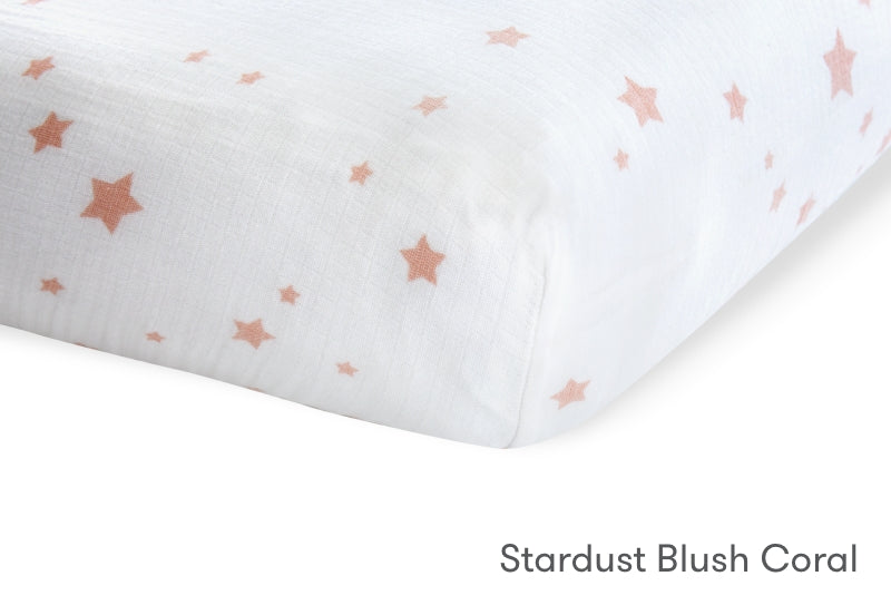 Close-up of a Newton Baby crib mattress in Stardust Blush Coral pattern with small pink stars. 999-3020-PSW 999-3520-PSW