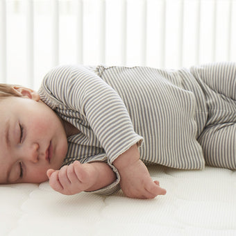 A peaceful baby sleeping soundly on a soft Newton mattress
