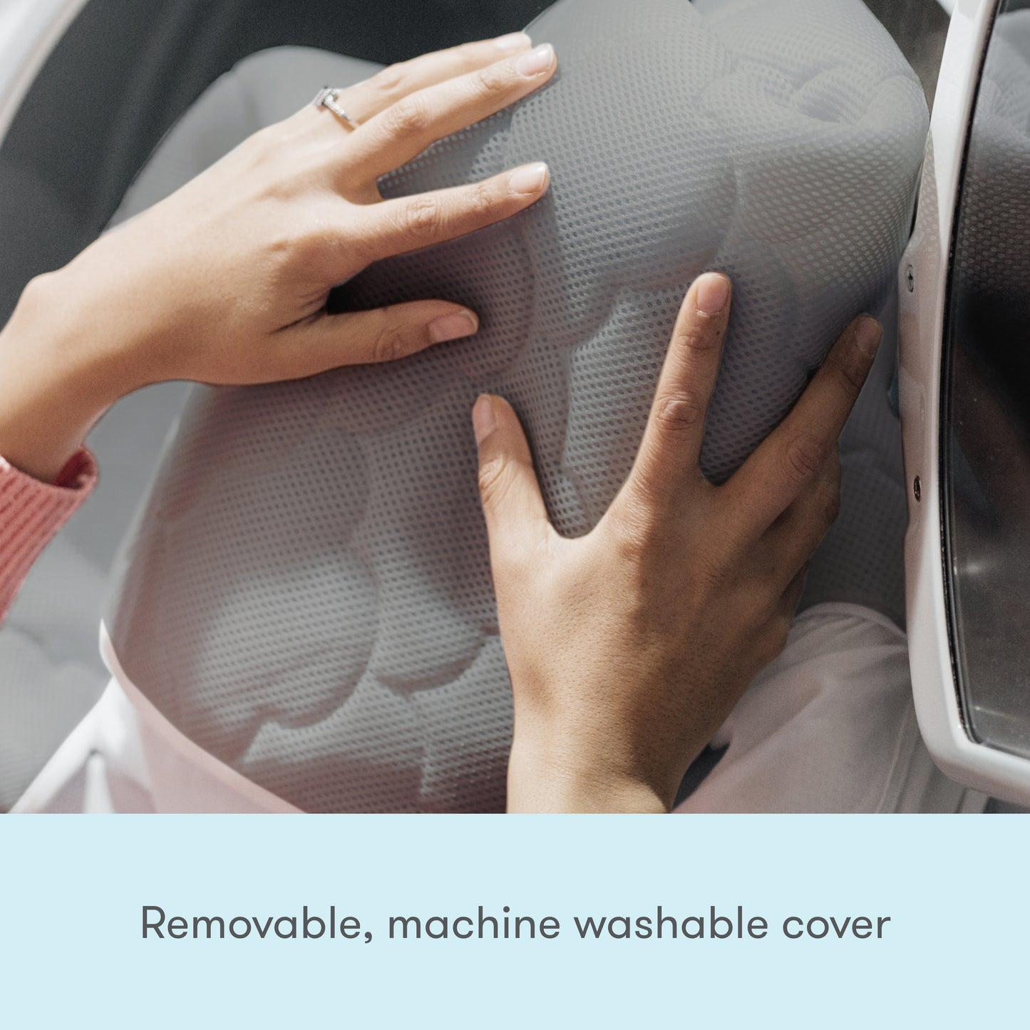 hands placing waterproof mattress cover in washing machine with text, "removable, machine washable cover"