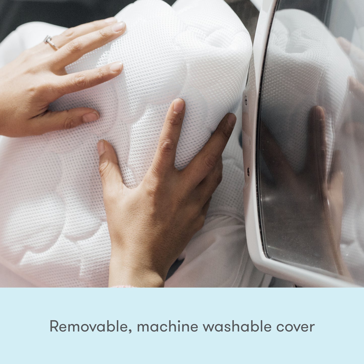 hands placing wateproof mattress cover in washing machine with text, "removable, machine washable cover"