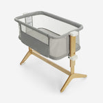 Modern gray baby bassinet with wooden legs and breathable mesh sides.