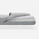 Newton Baby Crib Mattress partially unrolled to show its breathable design and washable materials, featuring a small Newton logo. skip