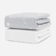 Stack of two baby mattresses with a star-patterned cover on the top mattress. skip