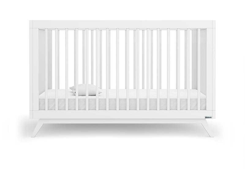 Modern white crib with a minimalist design and visible brand label, showcasing a slim mattress fitted inside. 500-8220-WHT