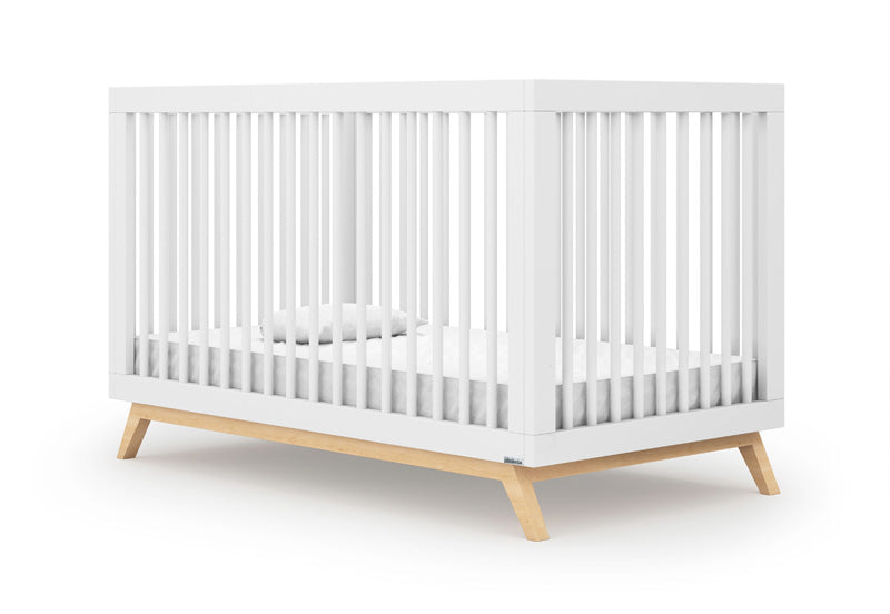 The dadada baby Soho Convertible Crib features a modern white 3-in-1 design with vertical slats and light wood base, paired with a Newton crib mattress, white sheet and pillow, styled on a plain white background for sleek mid-century appeal.