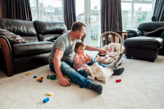 dad with child and baby rocker