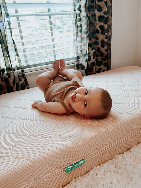 Baby laying on a crib mattress cover