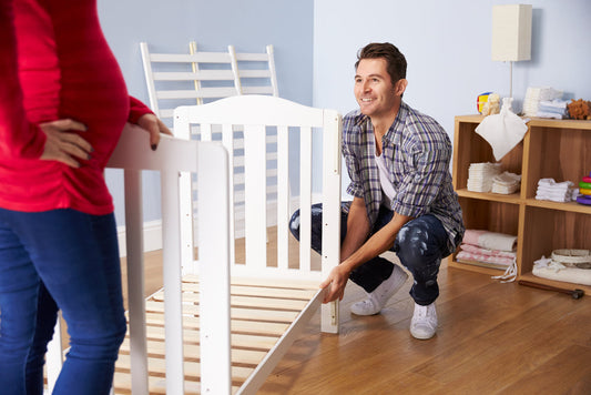 Pregnant mom and dad putting together a baby crib