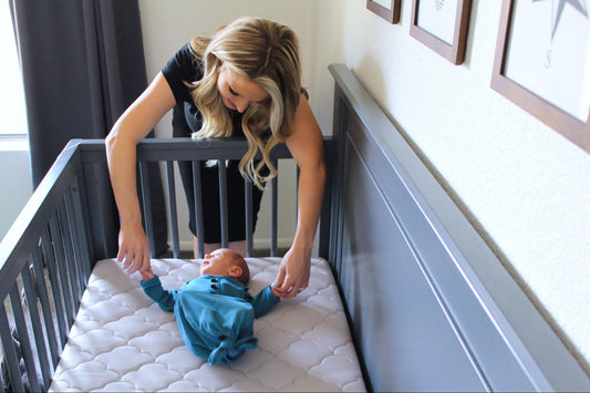 Mom showing how to put a baby to sleep in a crib