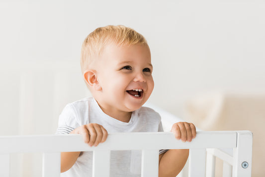 Baby standing in a mini crib