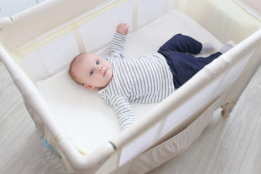 baby laying in travel crib